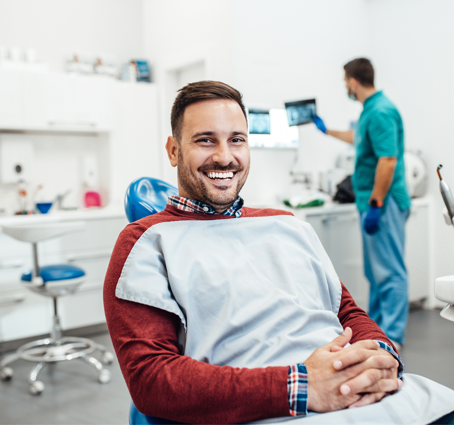 Smiling male patient relaxing in a dental chair after a successful dental appointment.