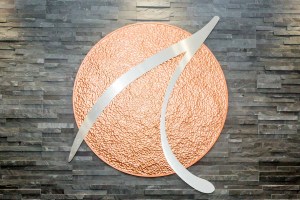 Reception counter with granite top, gray stone wall, and circular orange logo with silver swoosh